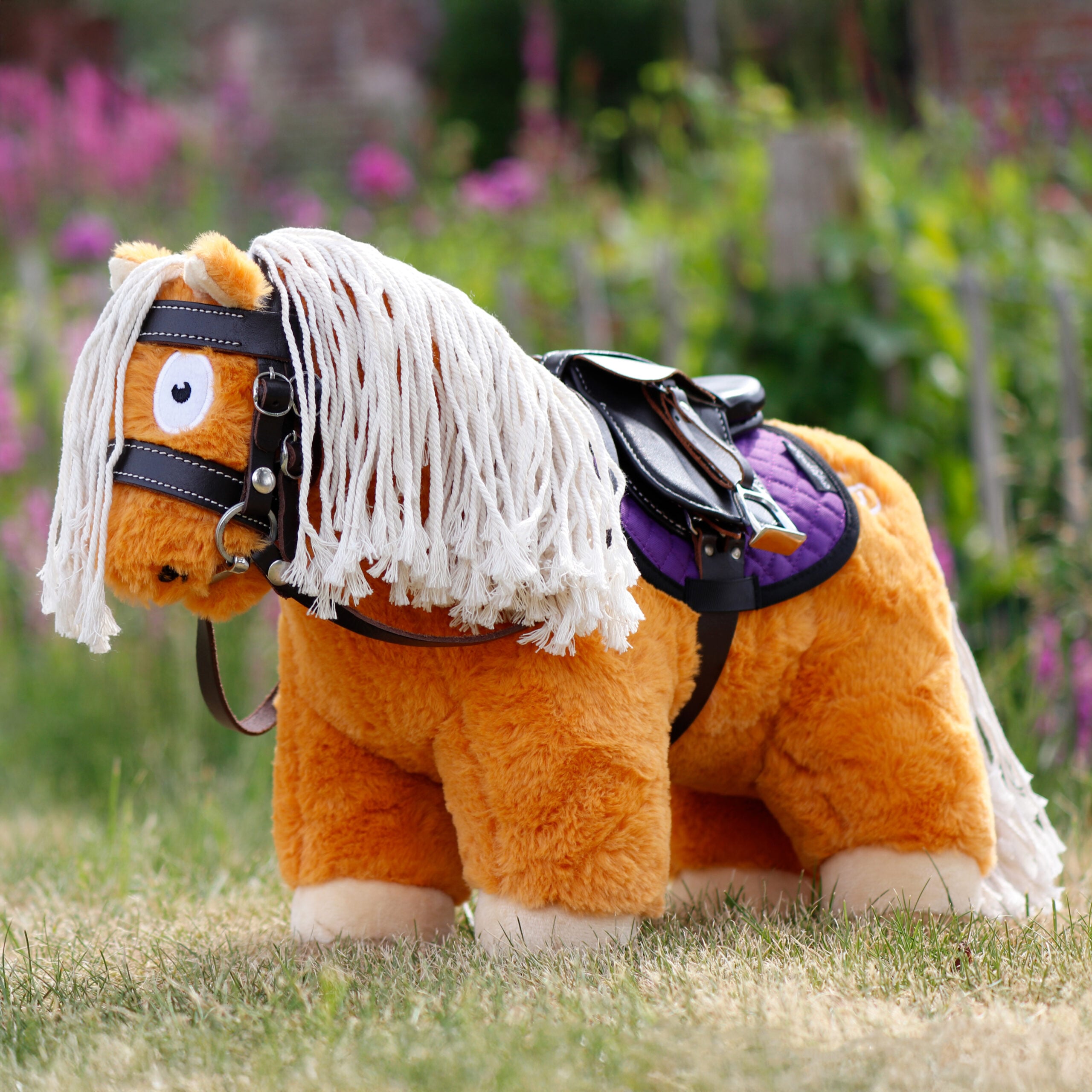 Crafty Ponies paardenknuffel met zadel, hoofdstel en zadeldekje op gras, educatief paardenspeelgoed