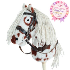 Bruin bont Crafty Ponies Hobby Horse stokpaard met witbruine vacht, lange witte manen en zwart hoofdstel, inclusief gratis hobby horse frontriem actiebadge.